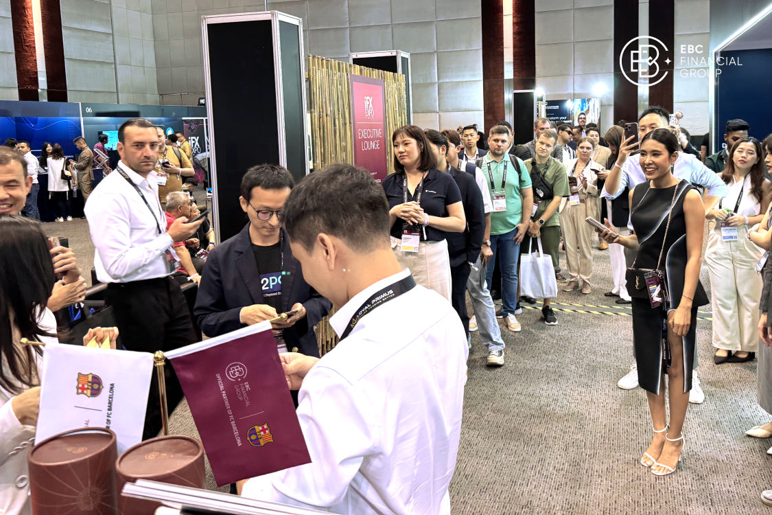 A group of iFX Expo Asia 2024 attendees queues at the EBC Financial Group booth