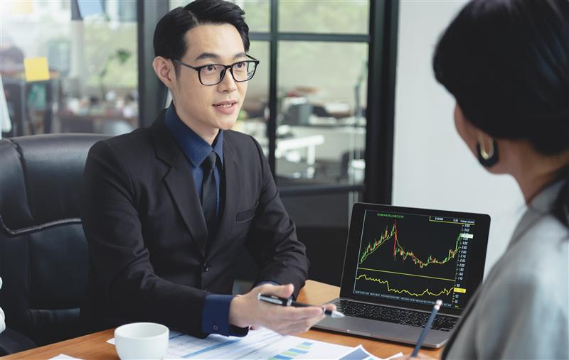 A group of Asian traders meeting to discuss a trading plan