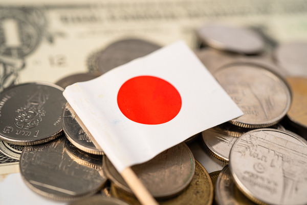 Stack of coins with Japan flag on white background.